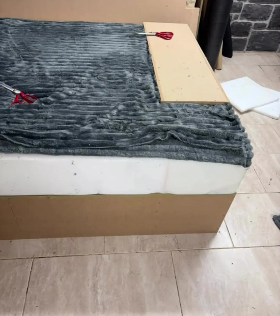 New foam fitted to a sofa base, ready to be covered in grey cord fabric