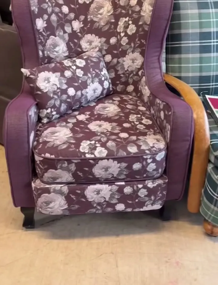 Wingback armchair reupholstered in a plum floral fabric with a matching cushion