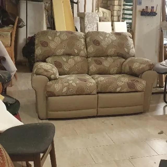 Two-seater recliner sofa reupholstered in a leaf-pattern fabric
